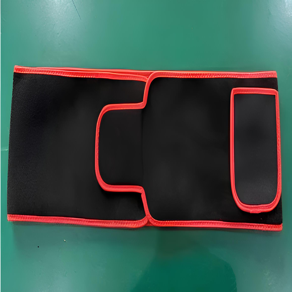 Black and red heat therapy wrap on green surface for pain relief and muscle recovery