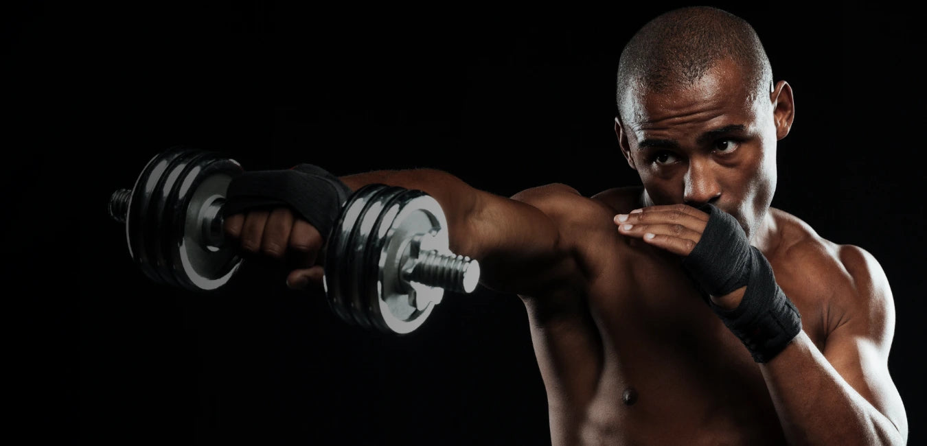 Athletic man with wrist wraps punching while holding a dumbbell, muscle recovery focus